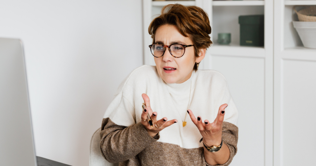 Woman with short hair talking with her hands in a frustrated tone